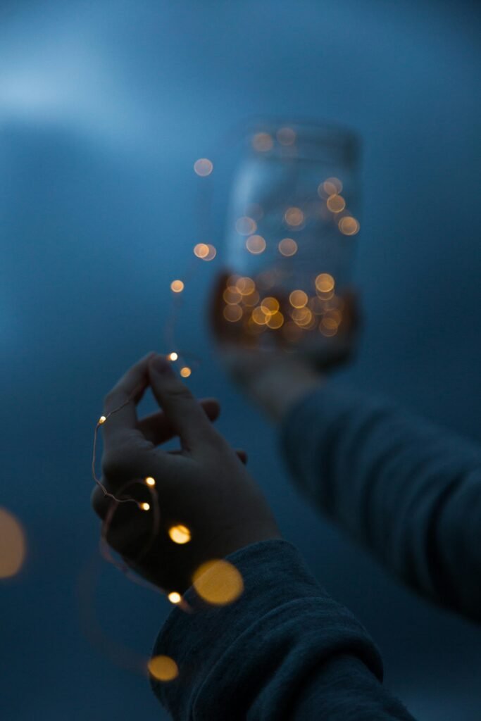 pexels photo 3378993 3378993 Hands holding a jar with glowing lights, creating a magical atmosphere at night.