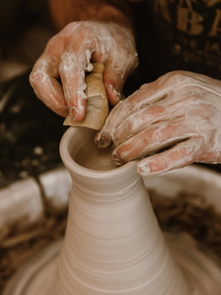 Skilled hands shaping clay on a pottery wheel, focusing on fine art craftsmanship.